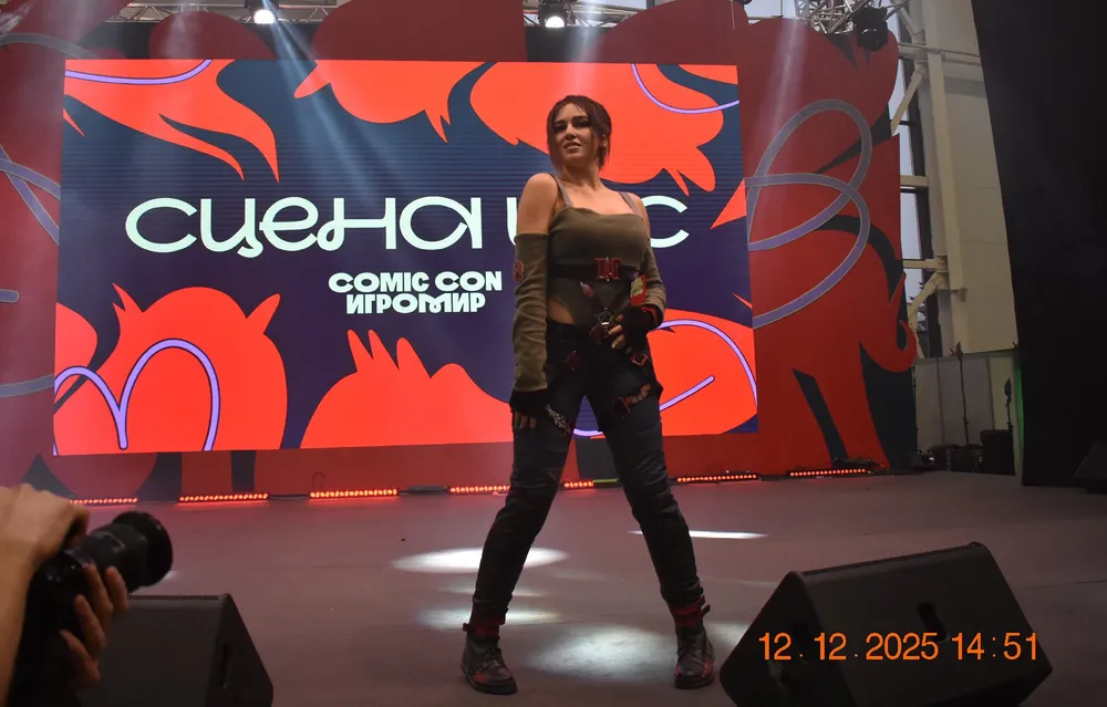 На картинке изображена женщина в костюме на мероприятии, фоновая реклама с надписью \