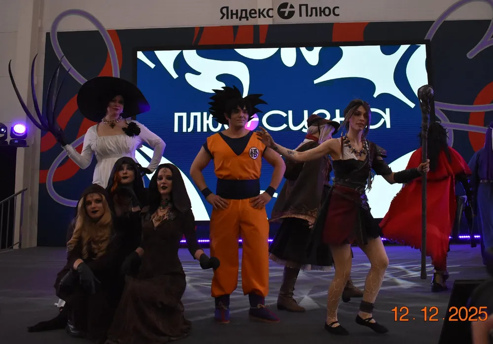 Группа людей в костюмах на сцене, мероприятие с декорациями и логотипом Яндекс.