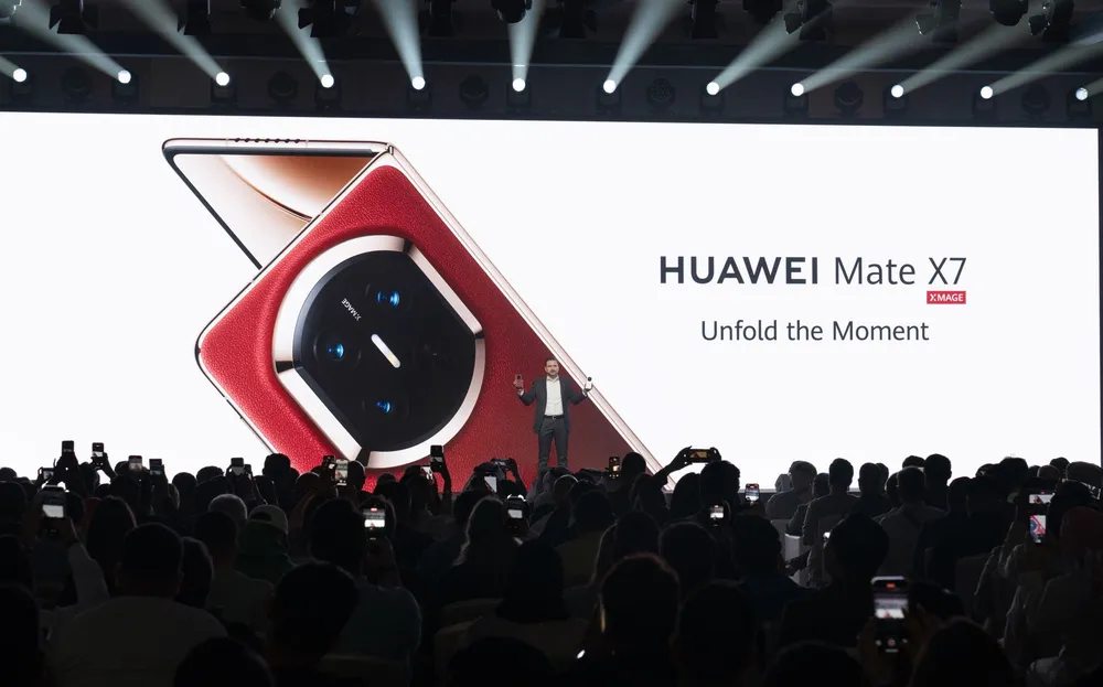 Презентация нового смартфона Huawei Mate X7, люди в аудитории, световое шоу.