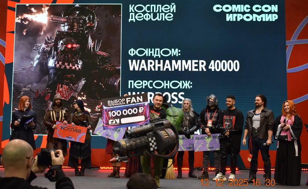 Изображение с Cosplay на Comic Con, участники в костюмах, баннер с информацией о фан-клубе Warhammer 40000.