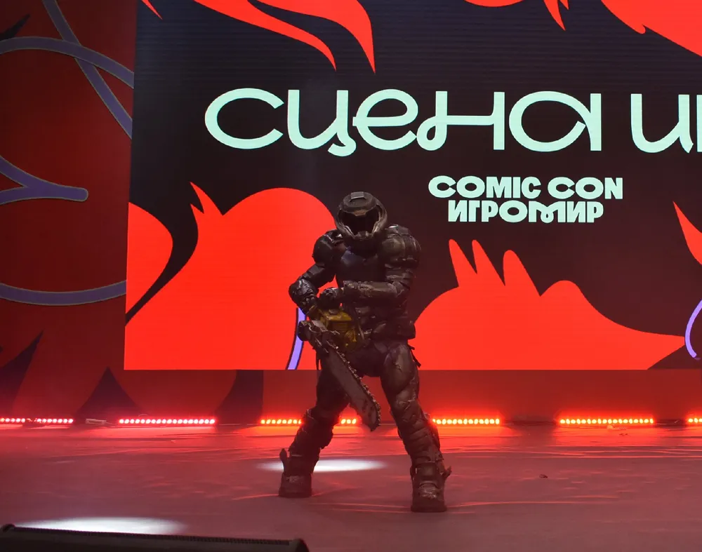 Изображение человека в костюме на мероприятии Comic Con, фон с текстом.