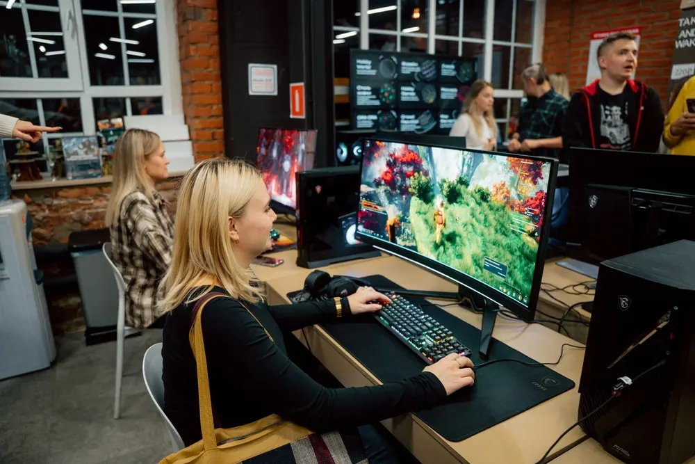 Изображение людей, работающих за компьютером, в игровой обстановке.