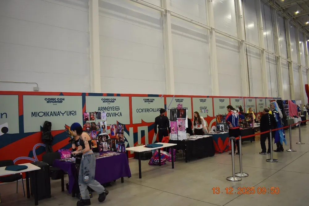 Выставка, стенды с товарами, люди, занимающиеся покупками или продажами.