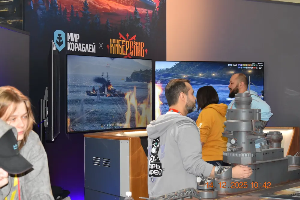 На изображении люди, которые взаимодействуют с выставочными стендами и экранами, демонстрирующими морскую тематику.