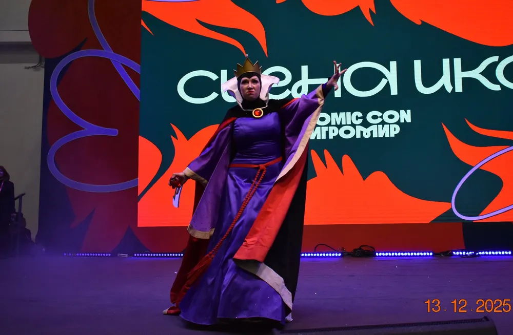 На изображении человек в костюме, возможно, на мероприятии, связанное с комиксами или анимацией. Фон содержит текст с названием события.