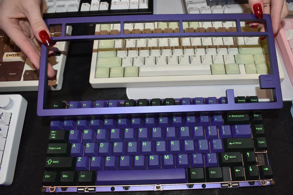 Изображение клавиатуры и рук, держащих рамку для клавиатуры.