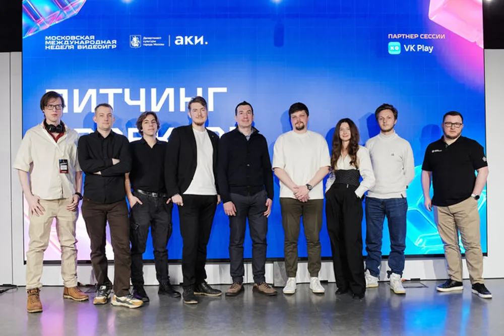 Группа людей на мероприятии, стоящих на фоне рекламного баннера.