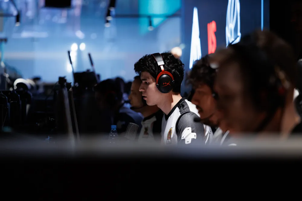 Сцена из игровой студии с несколькими игроками, использующими наушники и работающими за компьютерами.