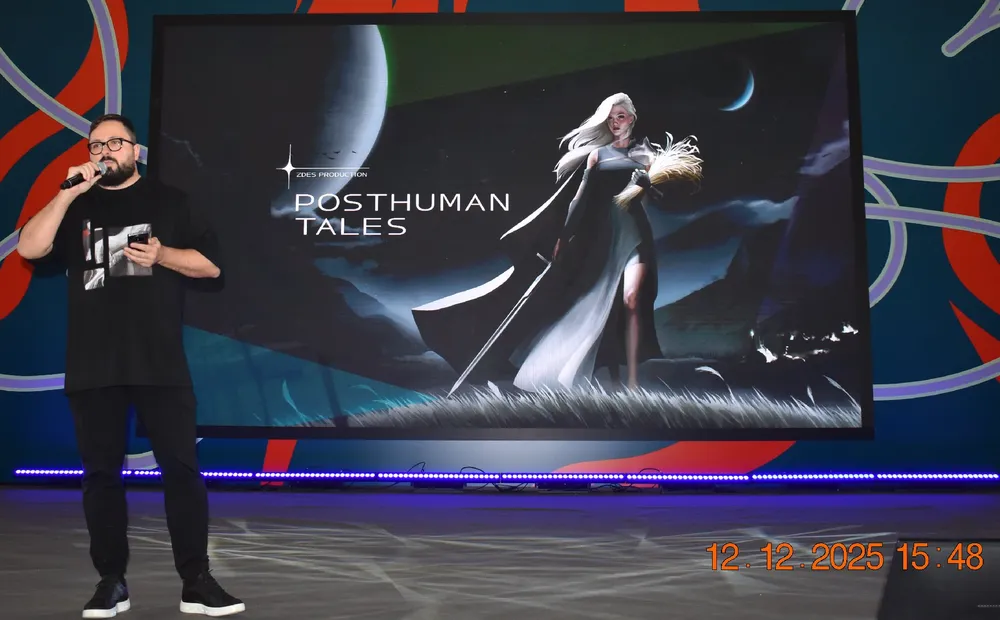 На изображении человек, стоящий перед экраном с изображением, на котором написано \