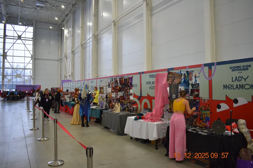 Изображение выставки или мероприятия с участниками в костюмах, стенды с товарами, интерьеры помещения.