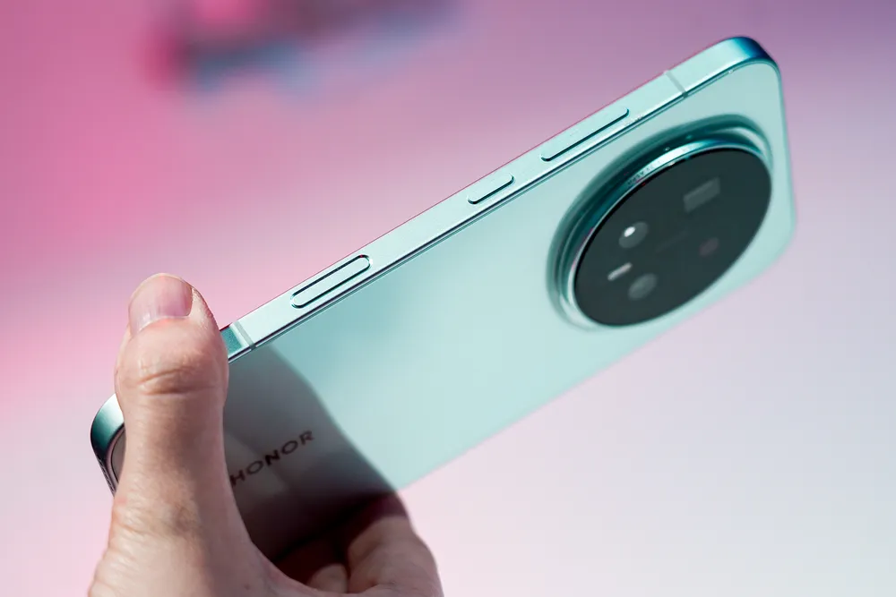 Изображение смартфона, снятое с руки, с фоном в розовых тонах.