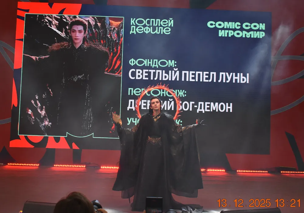 На изображении человек в костюме на сцене Comic Con, с текстом о персонаже и исполнителе.