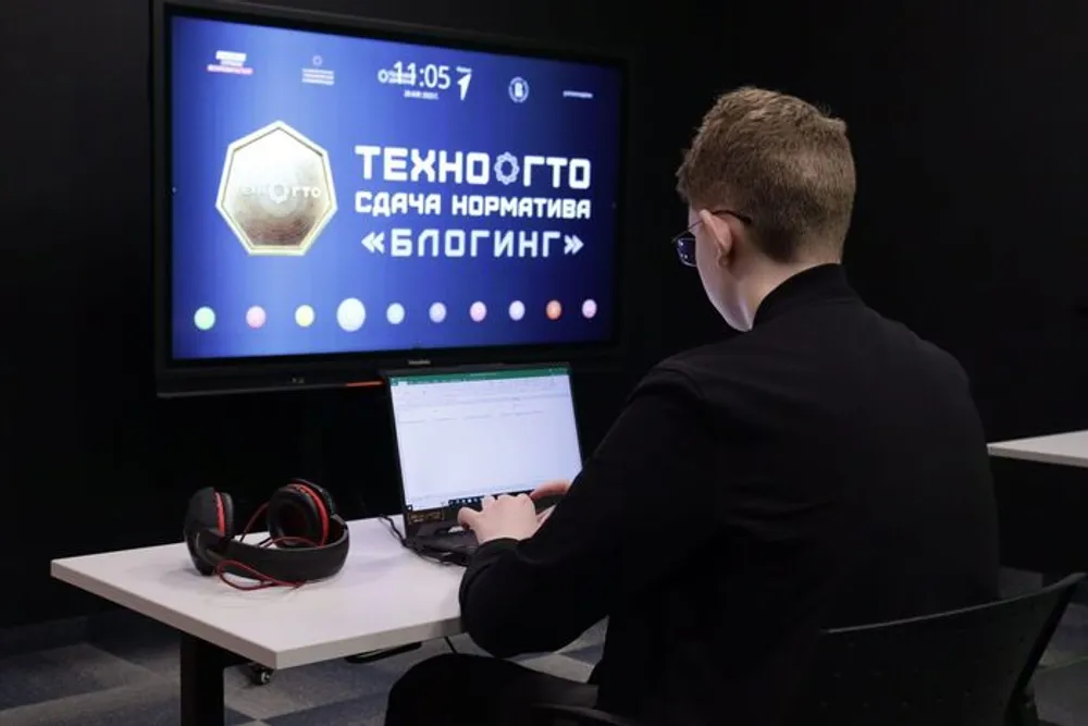 Изображение человека, работающего за компьютером, на фоне экрана с текстом о блогинге.