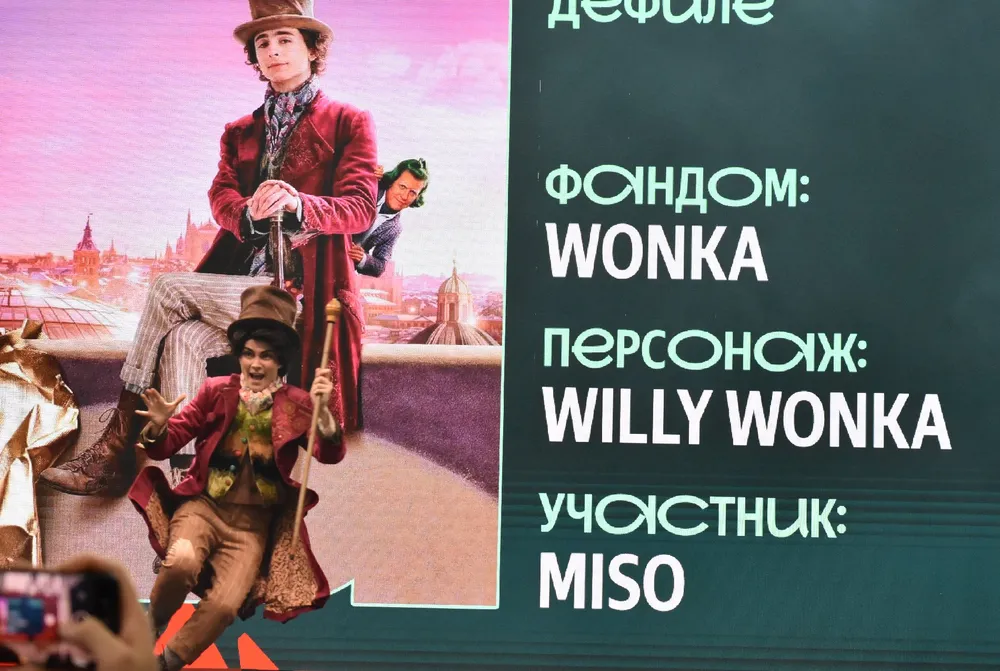 Изображение человека в костюме, текст с информацией о фандоме и персонаже Willy Wonka.