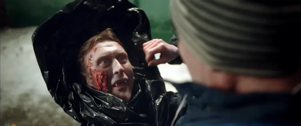 На картинке изображены два человека, один из которых находится в мешке, с явными признаками насилия и повреждений на лице.