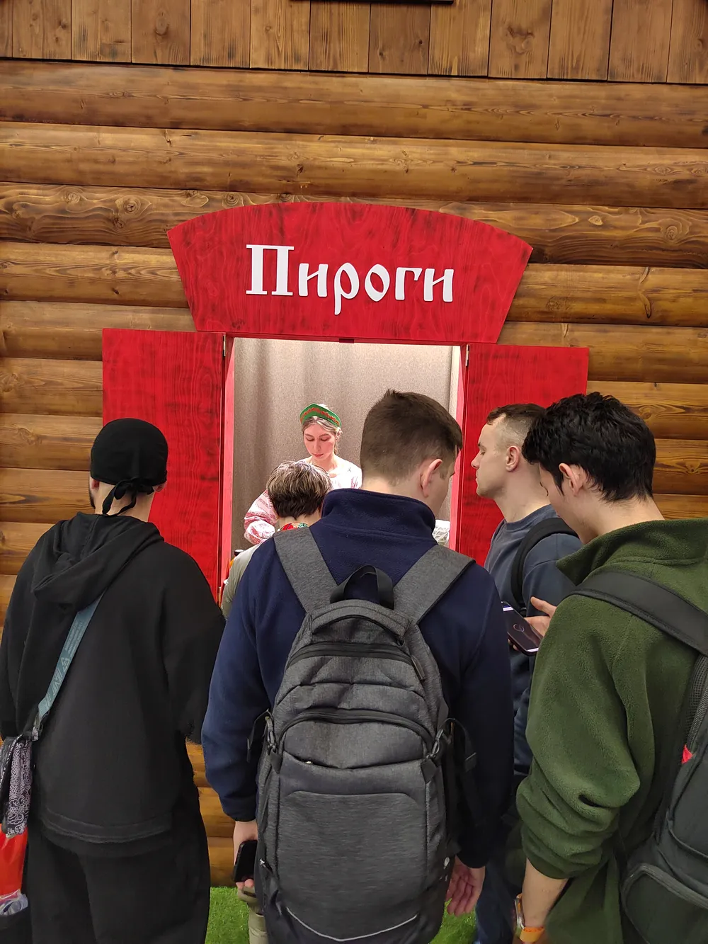 На картинке изображены несколько людей, стоящих в очереди к киоску с надписью \