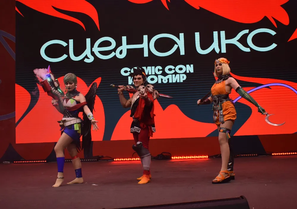 Изображение трех человек в костюмах на мероприятии, вероятно, связанном с комиксами или поп-культурой.