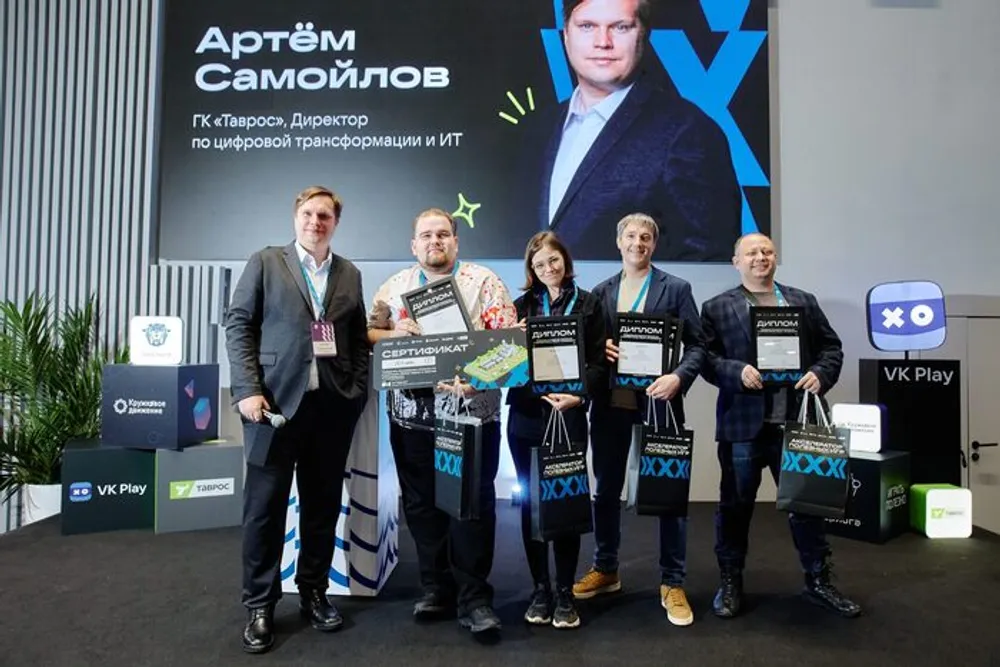 Группа людей на мероприятии, на фоне плакат с именем Артёма Самойлова. Участники держат награды или документы.