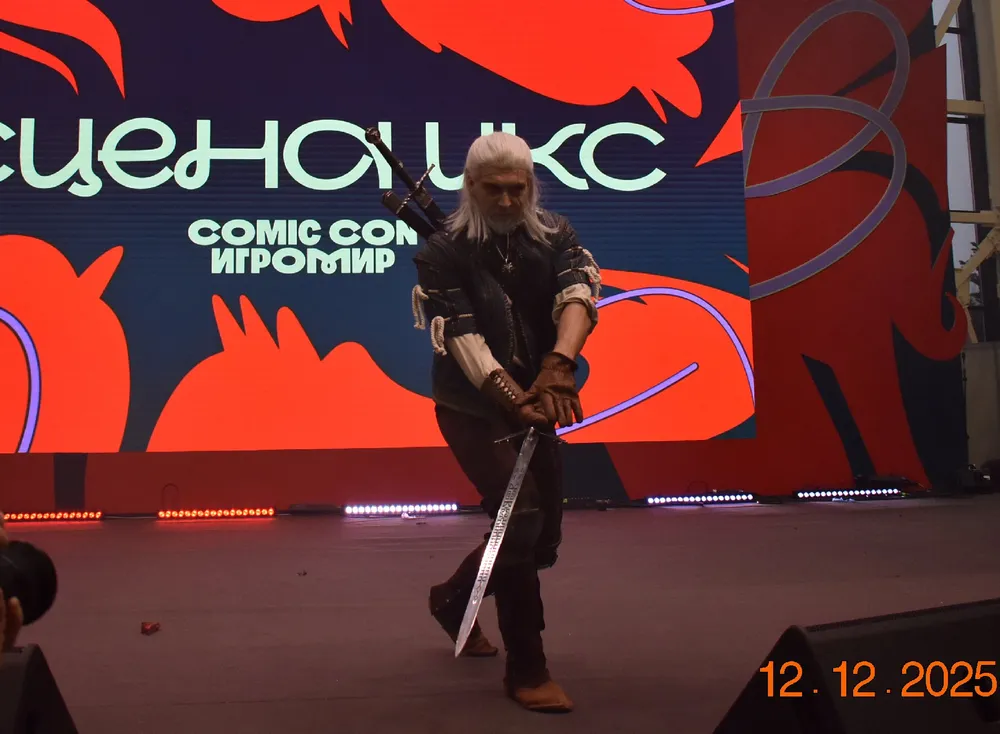 Изображение человека в костюме с мечом на фоне рекламы мероприятия.